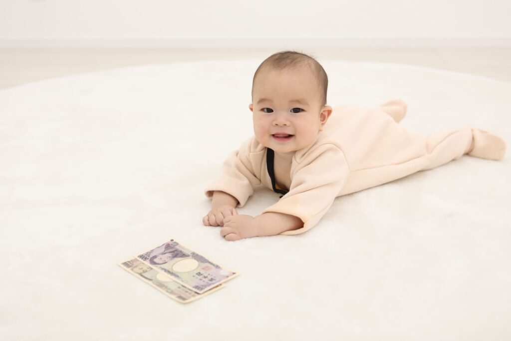 床に寝そべる赤ちゃんと紙幣