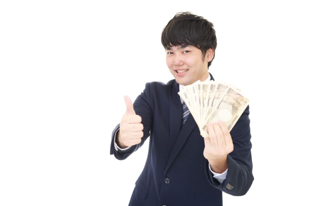 1万円札を持ち、笑顔のビジネスパーソン